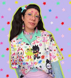 a woman wearing glasses and a shirt with cats on it's sleeves, standing in front of stars