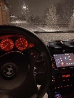 the interior of a car with dashboard lights on and steering wheel in front of it