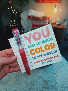 someone holding up a valentine's day card that says you add so much color to my world