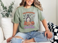 The perfect daycare provider shirt for this upcoming fall! Gift this colorful Halloween tee to to your kid's babysitter this spooky season! T-shirt description: A woman wearing a cute, vintage Comfort Colors T-shirt with the text The Spookiest Daycare. There are three smiling carved pumpkins sitting in front of a tombstone with a skeleton arm coming out of the ground and black bats in the air.  Unfortunately, at this time, we do not offer specialty gift wrapping. How to Order: 1) Check our photo Skeleton Arm, Teacher Tee Shirts, Picu Nurse, Colorful Halloween, Carved Pumpkins, Coffee Tees, Get Happy, Teacher Tees, Comfort Colors Shirt