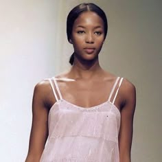 a woman is walking down the runway wearing a pink top