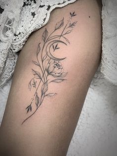 a woman's thigh with flowers and leaves on it