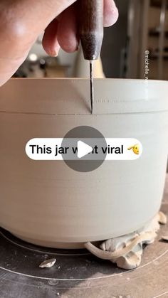 a person is using a sharpie to cut through the bottom of a white bowl