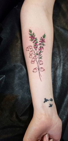 a person with a tattoo on their arm holding a flower in one hand and a butterfly in the other