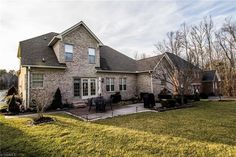 a large brick house sitting on top of a lush green field