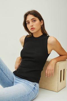 Round neck pullover style with tight fit silhouette. Ribbed knit top, stretchy. Rounded hem. Chic Stretch Knit Mock Neck Top, Black High Neck Top With Ribbed Neckline, Stretch Ribbed Turtleneck Tank Top, Ribbed High Stretch Top For Night Out, Black Fine Knit High Neck Top, Stretch Ribbed Mock Neck Top, Black Turtleneck Top With Ribbed Neckline, Fitted Black Ribbed Knit Top, Stretch Knit Top With Ribbed Neckline