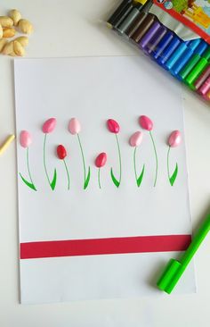 a paper with some flowers on it next to crayons