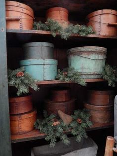 an old wooden shelf filled with buckets and pine cones