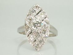 Up for sale is a gorgeous vintage diamond engagement ring that could also be worn as a lovely cocktail ring. It's a classic Navette shape and features 13 diamonds weighing an estimated 0.64 carats combined. The center stone is a gorgeous round transitional cut diamond measuring 4.46 x 4.5 mm and weighing an estimated 0.34 carats. It is a fine clean stone graded I color VS1 clarity. Accenting the stone are 12 single cut diamonds weighing 0.02 to 0.03 carats per and weighing an estimated 0.30 cara Vintage White Marquise Ring, Art Deco Diamond White Ring With 17 Jewels, Vintage Diamond White Diamond Ring For Formal Occasions, Vintage White Diamond Ring Brilliant Cut, Vintage White Diamond Ring With Brilliant Cut, Vintage Diamond White Baguette Cut Diamond Ring, Vintage White Marquise Cut Rings, Vintage White Diamond Baguette Cut Ring, Vintage Baguette Cut Diamond White Diamond Ring