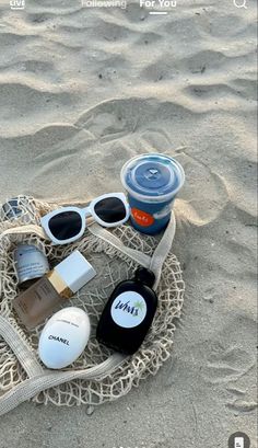 some items are laying out in the sand and on top of a netted bag