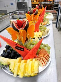 fruits and vegetables are arranged on white plates