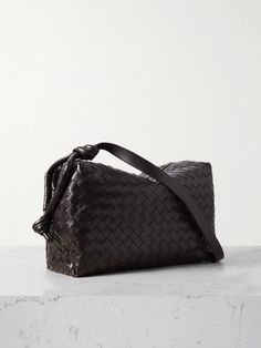 Bottega Veneta's weekend bag is made from strips of supple brown leather intricately woven using the label's intrecciato technique, which dates back to the late '60s - it's now renowned as an indication of impeccable craftsmanship. Perfect for an overnight stay or long commute, it's designed with an adjustable strap featuring the signature knotted details.  There's enough space inside for your cosmetics pouch, change of clothes and water bottle. Brown Intrecciato Weave Evening Shoulder Bag, Leather Shoulder Bag With Top Handle And Interwoven Design, Designer Travel Shoulder Bag With Interwoven Design, Designer Brown Woven Leather Shoulder Bag, Formal Brown Woven Leather Shoulder Bag, Leather Evening Bag With Interwoven Design, Luxury Brown Shoulder Bag With Interwoven Design, Leather Shoulder Bag With Intrecciato Weave For Evening, Brown Top Handle Shoulder Bag With Interwoven Design