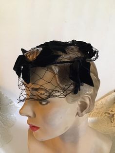 "Vintage 1950's 1960's Black hat with Black Velvet bows and veiling. No makers label. *MORE INFORMATION BELOW* CONDITION: I note a split in the veiling in the front (SEE PIX). MEASURES: Front to back~6\" Left to right~6\" *WE APOLOGIZE~BUT WE NO LONGER SHIP TO GERMANY, ITALY OR SPAIN. IF ORDERS COME IN FROM GERMANY, ITALY OR SPAIN, WE WILL HAVE TO CANCEL THEM AND REFUND YOUR MONEY. SORRY FOR THIS INCONVENIENCE*" Vintage Black High Crown Hat, Vintage Black Adjustable Hat, Vintage Black 5-panel Hat, Vintage Black Hat Headpiece, 1960s Pillbox Hat, 1960s Hats, Velvet Bows, Black Velvet Bow, Vintage Clothing Boutique