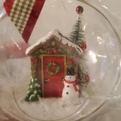 a snow globe with a christmas scene in the center and a small house on top