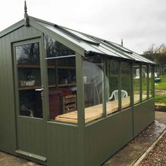 a small green building with a covered porch