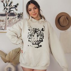 Tiger Face Sweatshirt, Tiger Hoodie, Vintage Tiger Hoodie, Trendy Tiger Sweatshirt, Animal Face Hoodie, Fashion Hoodie Looking for additional graphic chic merch? Check these out: https://www.etsy.com/shop/TheGraphicPeach?ref=seller-platform-mcnav§ion_id=30396058 Our shop uses direct-to-garment printing to make our products. The design ink is sprayed on, then allowed to soak into the fibers of the garment. This process yields fine quality prints and a smooth finish on the garment. GILDAN UNISEX H Tiger Gifts, Tiger Hoodie, Vintage Tiger, Tiger Face, Sweat Shirts, Fun Sweatshirts, Gildan Sweatshirts, Animal Faces, Limassol