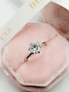 an engagement ring in a pink velvet box