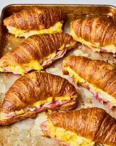 several croissants with ham and cheese on them