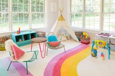 a child's playroom with colorful rugs and furniture