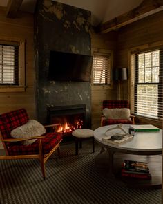 a living room filled with furniture and a fire place in the middle of a room