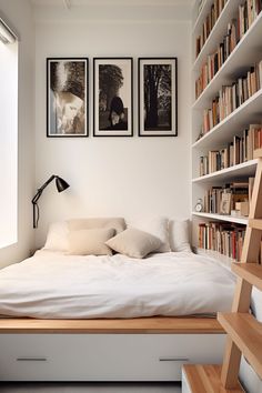 a bed with white sheets and pillows in front of bookshelves filled with books