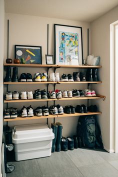 there are many pairs of shoes on the shelves in this room and one is empty