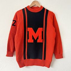 true vintage 1970's varsity sweater  orange and black colors with orange "M" and "72" right sleeve patches. 100% virgin wool. Whiting brand. Chain stitched name "Perez" on tag. fits size medium  18.5" chest, 25" length  great worn condition Retro Sweater For College In Fall, Collegiate Red Sweater For Fall, Vintage College Sweater For Fall, Vintage Sweater For College In Fall, Vintage Fall Sweater For College, Vintage Orange Sweater For Fall, Colors With Orange, Varsity Sweater, Chain Stitch