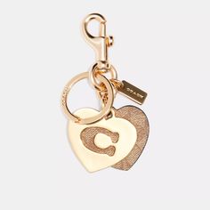 Add A Touch Of Elegance To Your Keys With This Nwt Coach Signature Hearts Key Ring Bag Charm Purse Keychain In Gold/Khaki. The Heart-Shaped Keychain Features The Coach Signature And A Detachable Key Ring, Making It A Versatile Accessory For Everyday Use. Measuring 1.75 Inches In Length And Width, The Keychain Is Made Of Durable Metal And Has A Stylish Design That Fits Any Fashion. Whether You Are A Fan Of The Coach Brand Or Simply Love The Heart Theme, This Keychain Is A Must-Have For Your Colle Metal Heart Keychain, Elegant Bag Charm With Logo, Gold Logo Charm Bag Charm, Everyday Bag Charm With Lobster Clasp, Logo Charm Bag For Everyday Use, Coach Gold Heart-shaped Jewelry, Coach Heart-shaped Gold Jewelry, Heart Theme, Purse Keychain