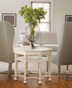 a living room filled with furniture and a vase full of flowers on top of a table