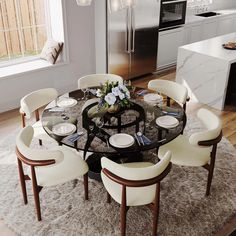 a dining room table with white chairs and a glass top centerpiece on a rug