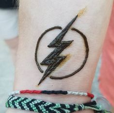 a person with a tattoo on their wrist has a lightning bolt tattooed on it's arm