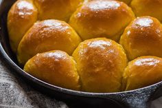 a pan filled with bread rolls on top of a table