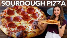 a woman holding a pizza on top of a wooden table with the words sourdough pizza