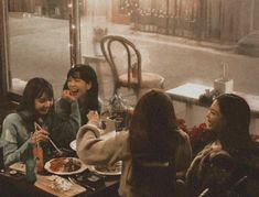 four women sitting at a table eating food