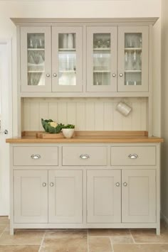 a white cabinet with glass doors and drawers