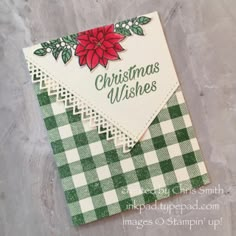 a christmas card with a red poinsetti on the top and green checkered paper