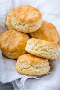 four biscuits are stacked on top of each other in a white dish with a napkin