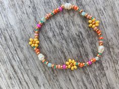 a multicolored beaded bracelet on top of a wooden table