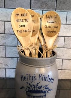 some wooden spoons in a pot with writing on them