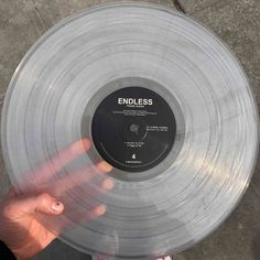 someone holding up a clear vinyl record with the word endless on it's side