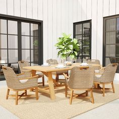 an outdoor dining table with chairs and a potted plant in the middle on a rug