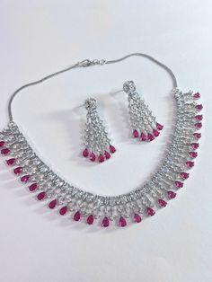 Gorgeous fine quality faux ruby pink color stone with CZ stones  studded in white gold rhodium plating with CZ high quality stones Comes with matching earrings. AAA quality cubic zirconia used. Highest quality and craftsmanship Necklace Fitting is adjustable comes with silver plated back metal chain Earrings Closure: Pushback Necklace Closure: Hook Pink Crystal Jewelry Sets For Formal Occasions, Formal Pink Crystal Jewelry Sets, Elegant Pink Crystal Jewelry Sets, Silver Ruby Jewelry With Prong Setting, Hand Set Ruby Jewelry Sets In Fine Jewelry Style, Fine Jewelry Sets With Hand Set Rubies, Hand Set Ruby Jewelry Sets, Fine Jewelry Ruby Sets, Pink Hand Set Jewelry For Formal Occasions