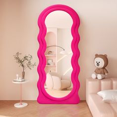 there is a large pink mirror in the room with a teddy bear on the floor