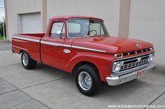 an old red truck parked in front of a building