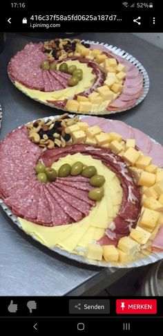 two plates with different types of food on them, one has olives and the other has meat