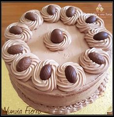 a chocolate cake with white frosting and nuts on top