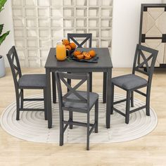 a dining room table with chairs and fruit on the plate next to it, in front of a white wall