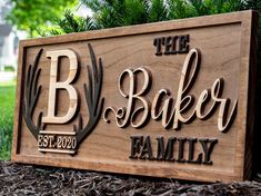 a wooden sign that says the baker family on it in front of some grass and trees