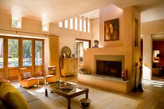 Earth tone palette in modern Los Angeles living room with fireplace, ribbon windows, skylights & tons of natural light & shadows. Modern Adobe House, Open House Plans