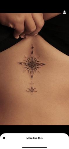 the back of a woman's stomach with a flower tattoo on her left side